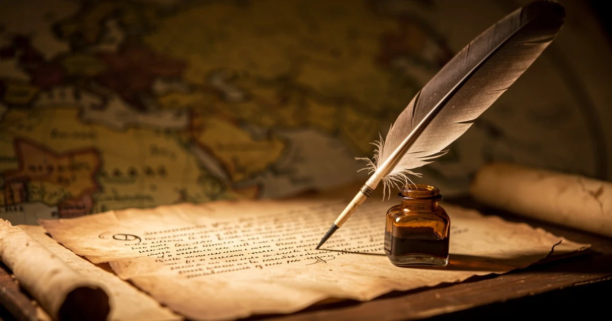Documento antiguo con pluma y tintero sobre un mapa mundial desenfocado